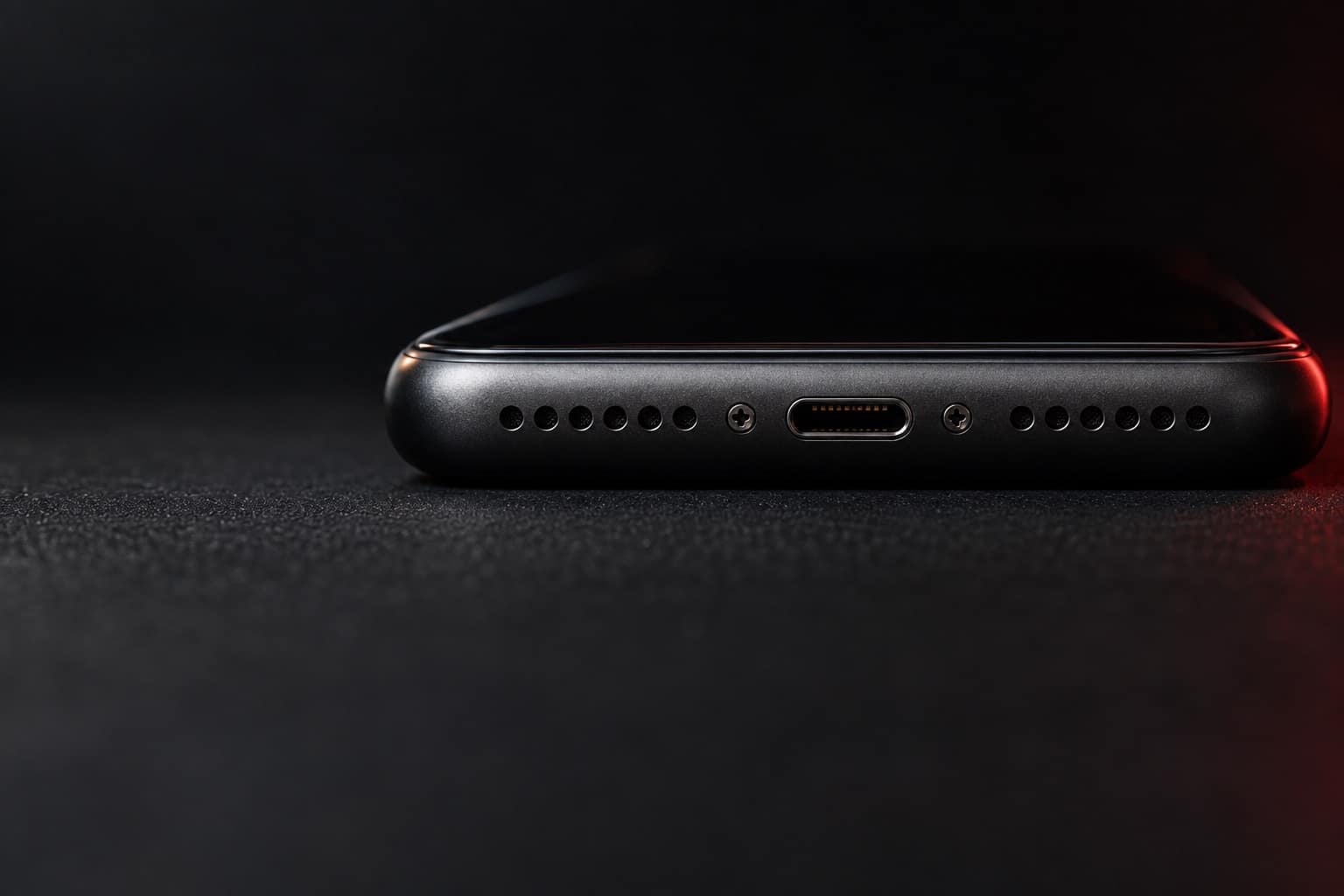 Borde inferior de un iPhone 11 negro con el puerto de carga Lightning y las rejillas del altavoz